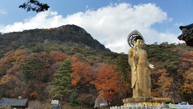 伫立于俗离山大绝壁前的弥勒石佛